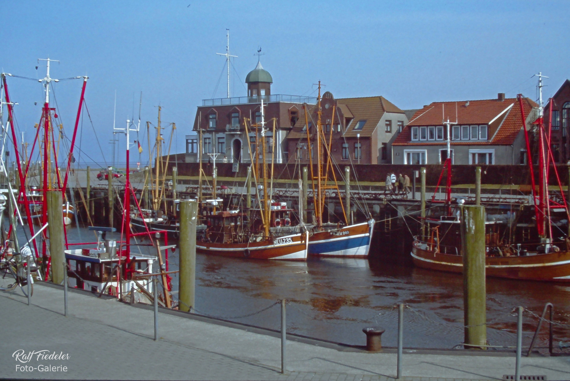 Fischkutter in Neuharlingersiel mit Café Störmhuus