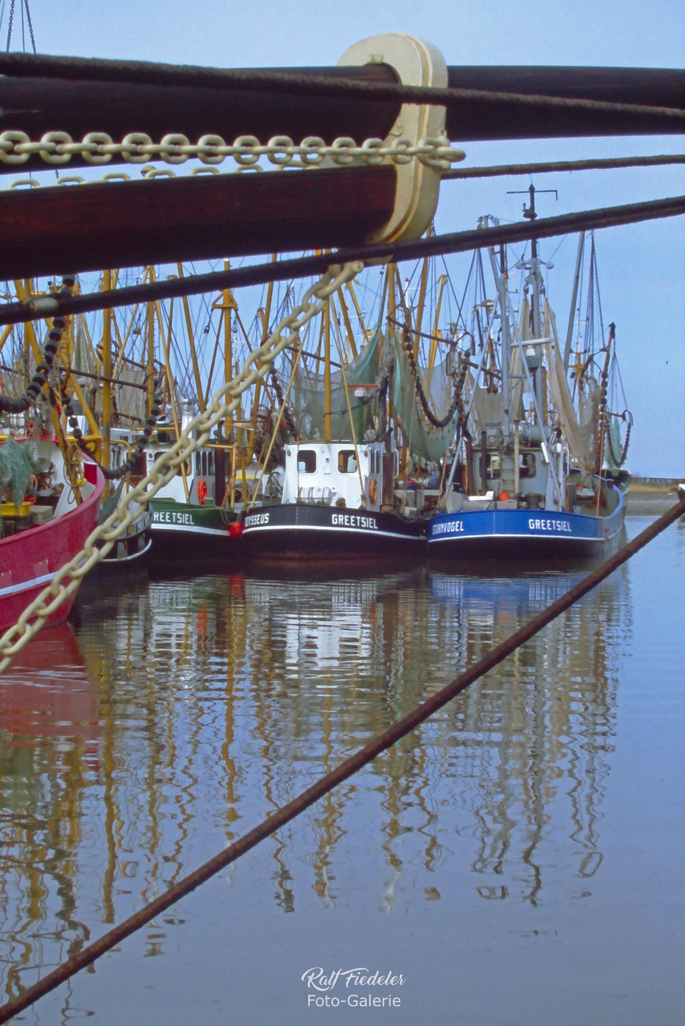 Fischkutter in Greetsiel und der Fockmast im Vordergrund
