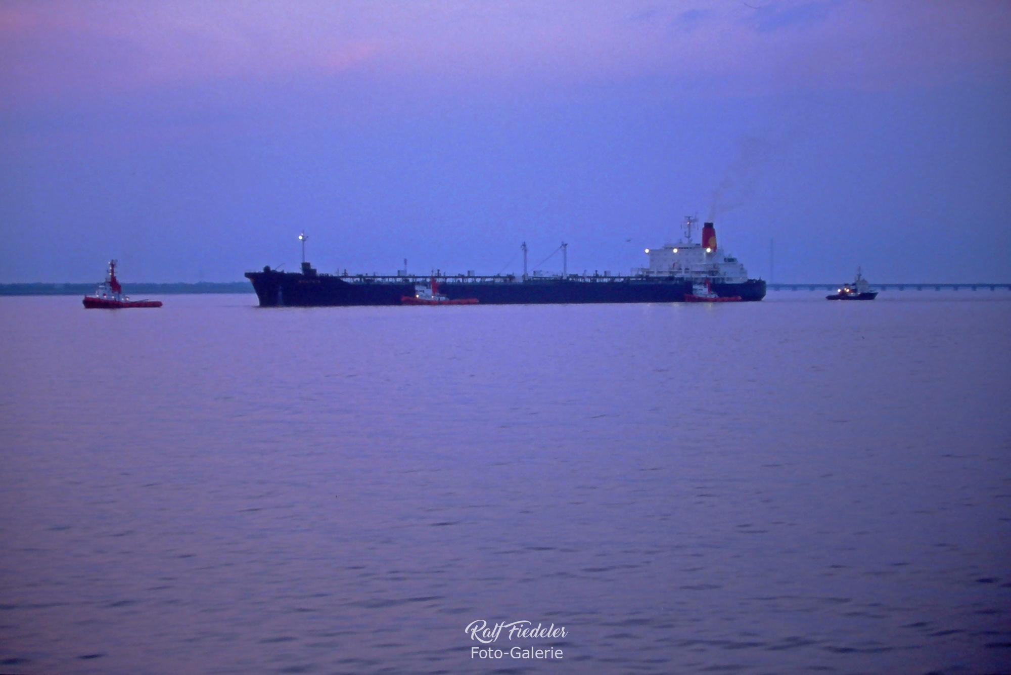 Öltanker im Abendlicht mit vier Schleppern