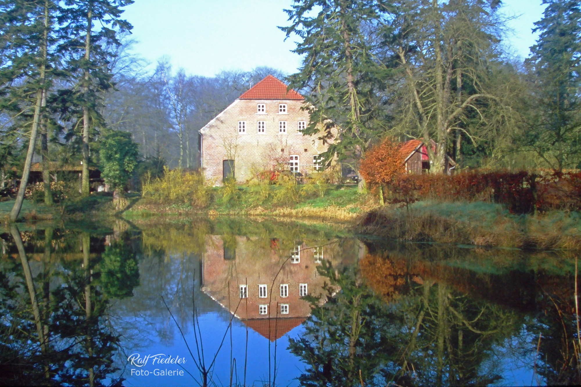 Forsthaus Upjever mit Teich davor und Wasserspiegelung