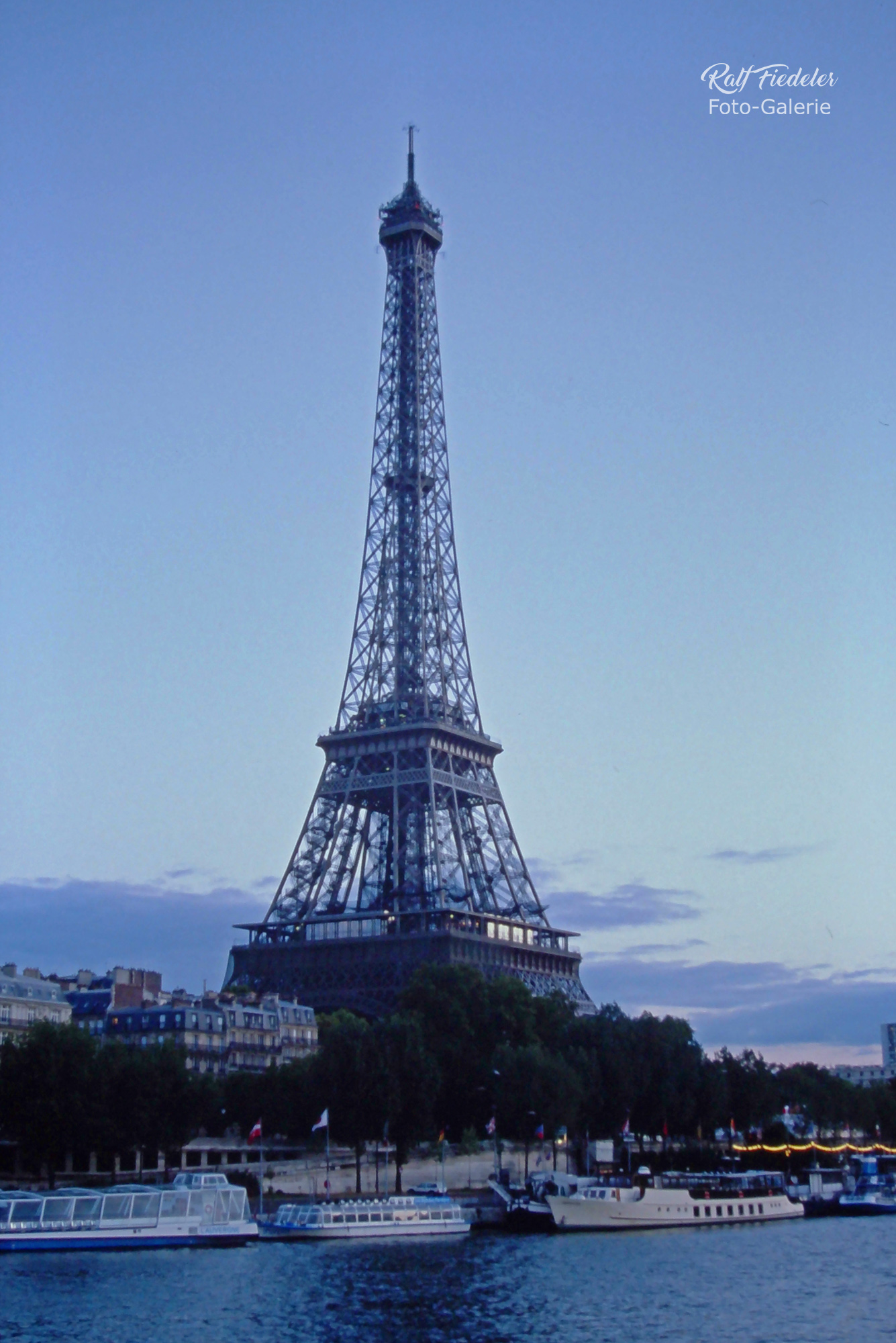 Unbeleuchteter Eifelturm am späten Nachmittag und im Vordergrund die Seine