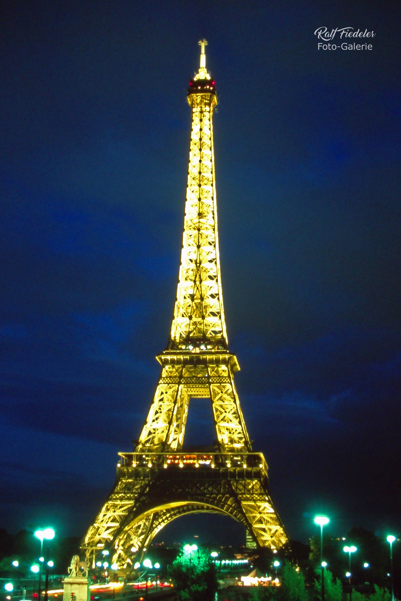 Beleuchteter Eifelturm am Abend von schräg über die Seine fotografiert