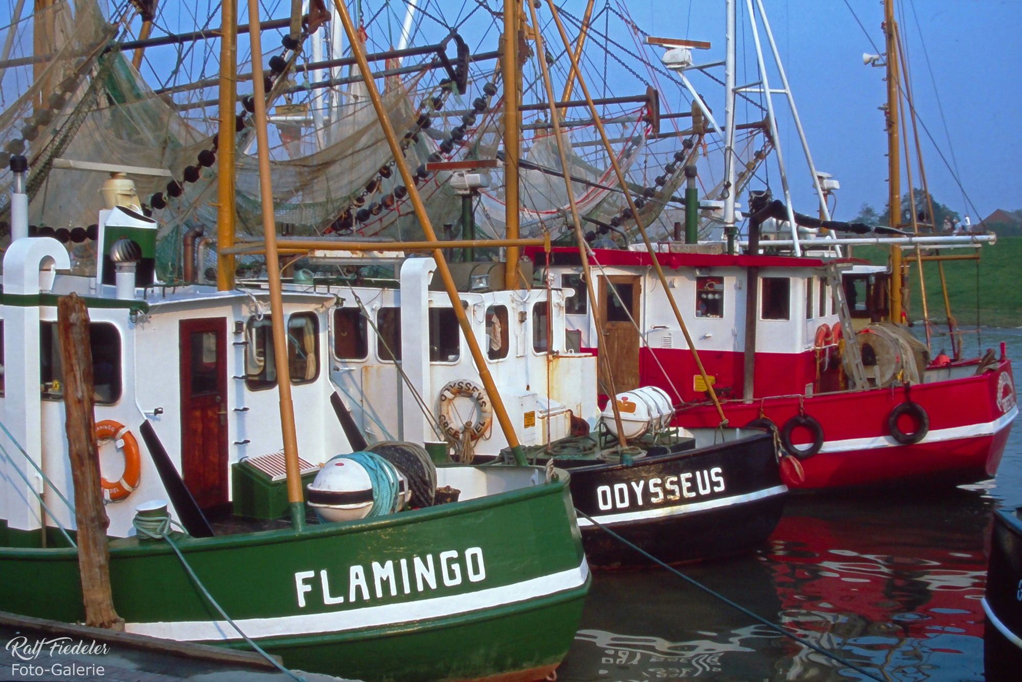Bildausschnitt von drei Fischkuttern im Hafen von Greetsiel