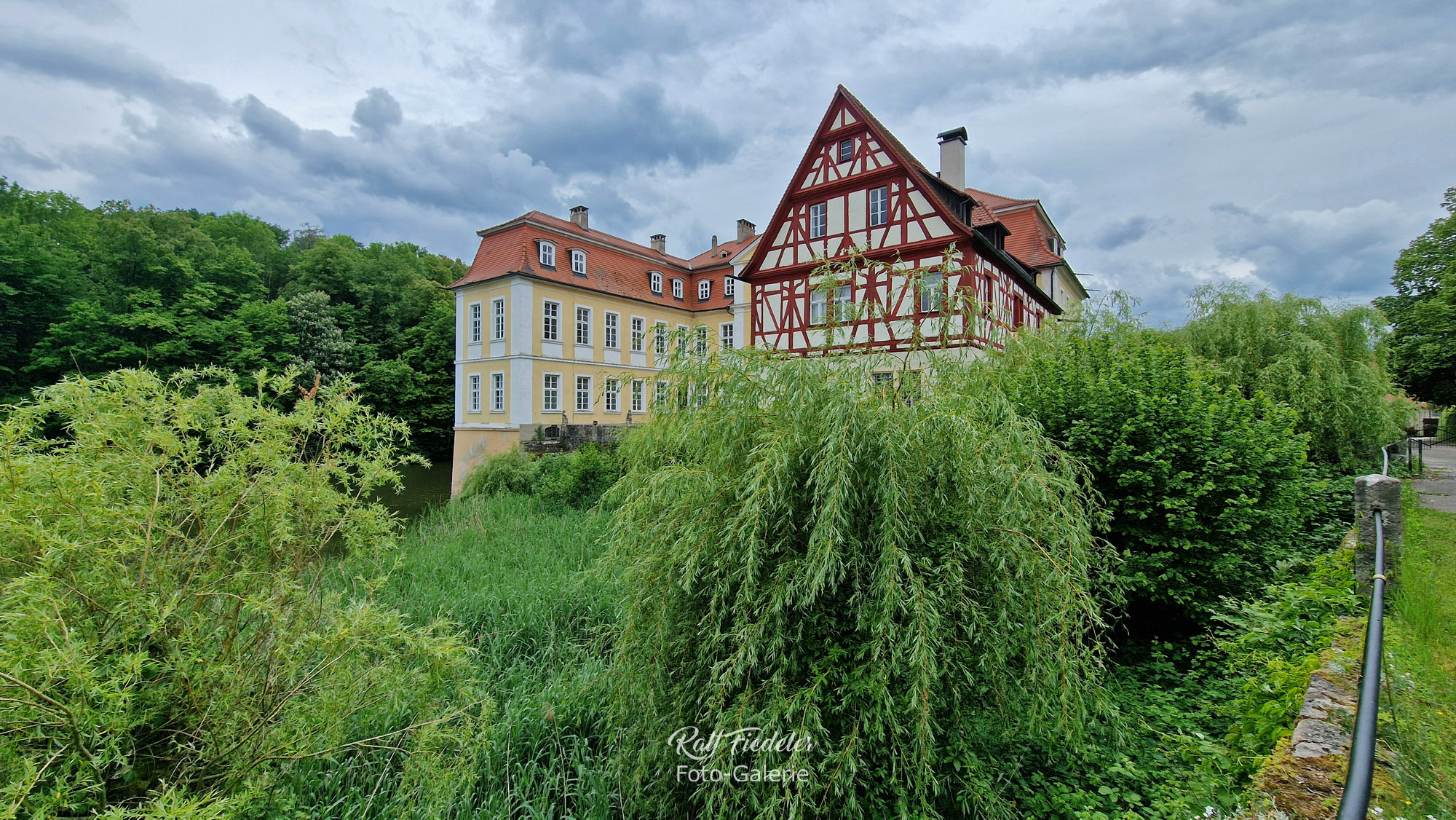Schloss Rügland die Frontansicht seitlich mit See links vom Schloss