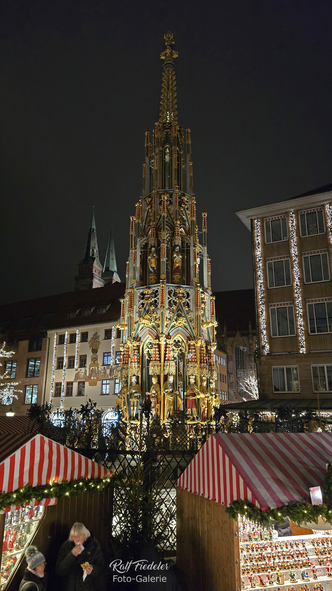 Schöner Brunnen auf dem Nürnberger Christkindlesmarkt mit Sebalduskirche im Hintergrund